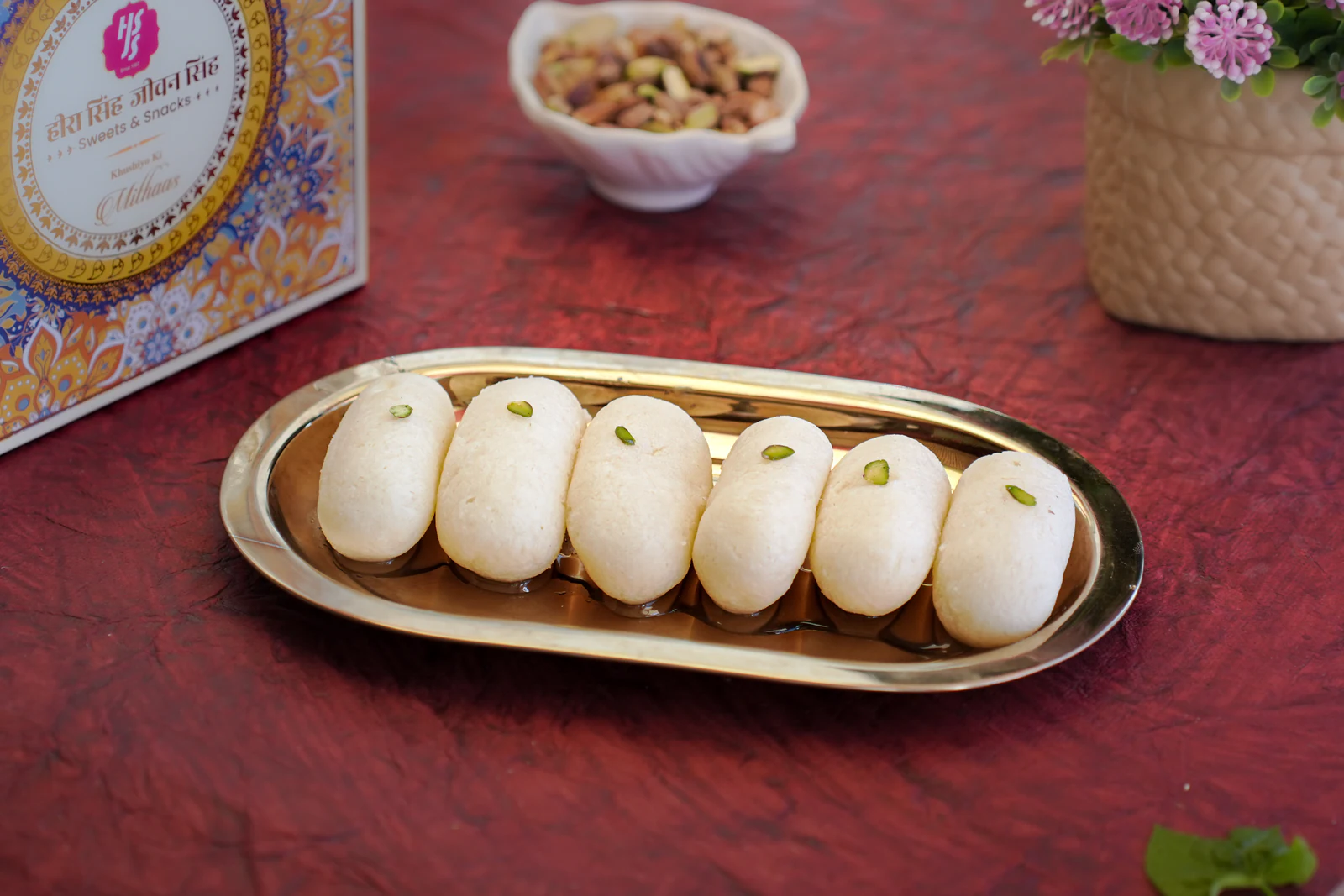 Pale cham cham arranged in a row, each topped with pistachio