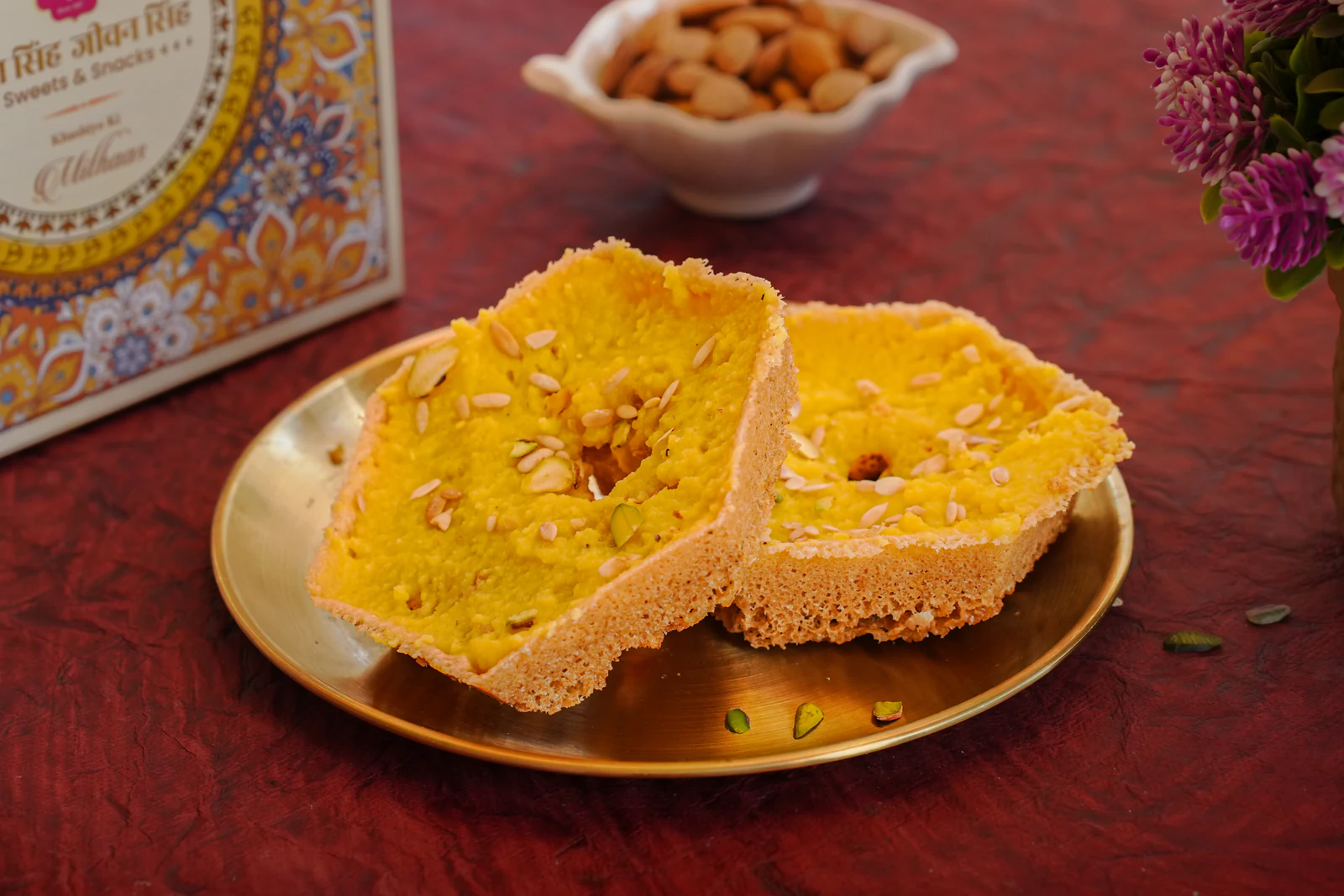 Two golden ghewar discs on a brass plate